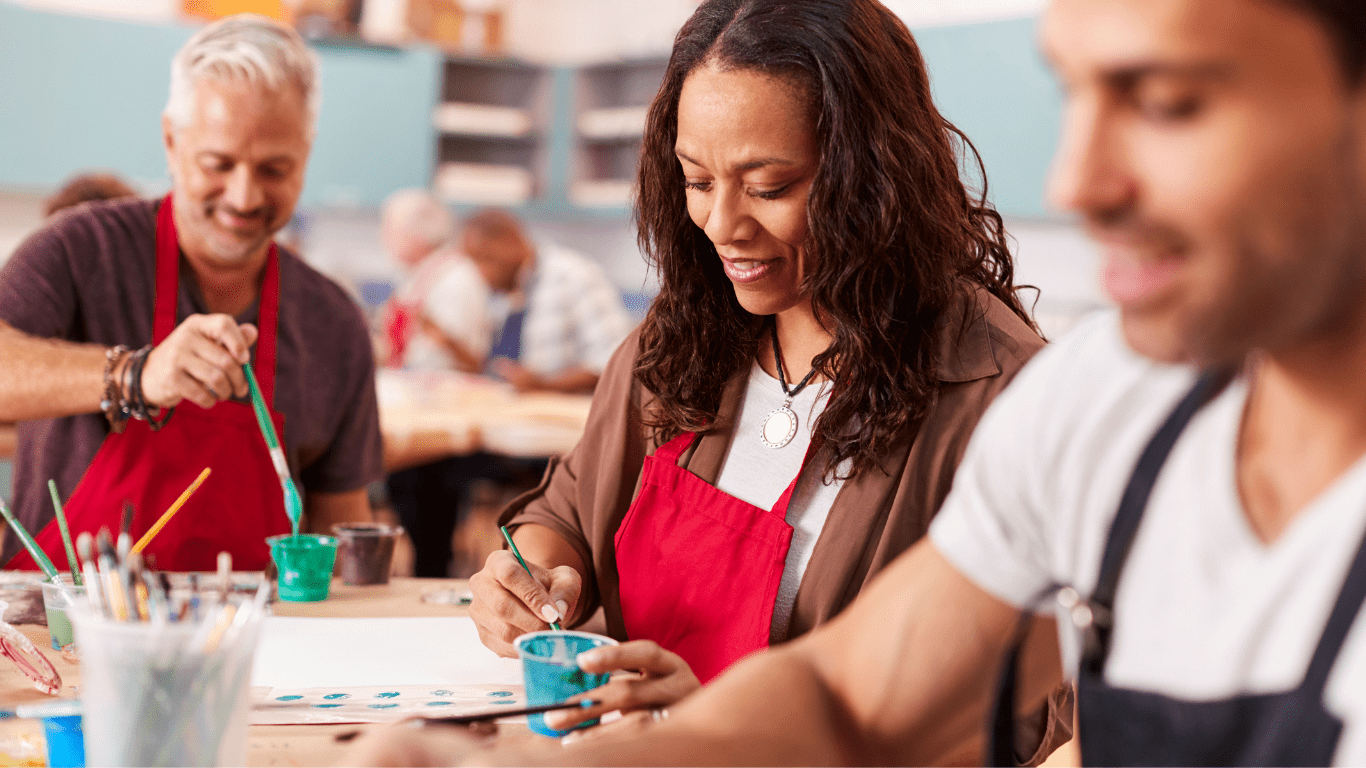People enjoying an art session, painting together in a supportive environment.