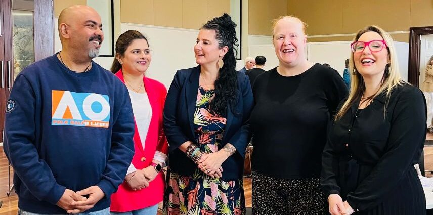 A group of five attendees smiling together at the MHCSA Annual AGM